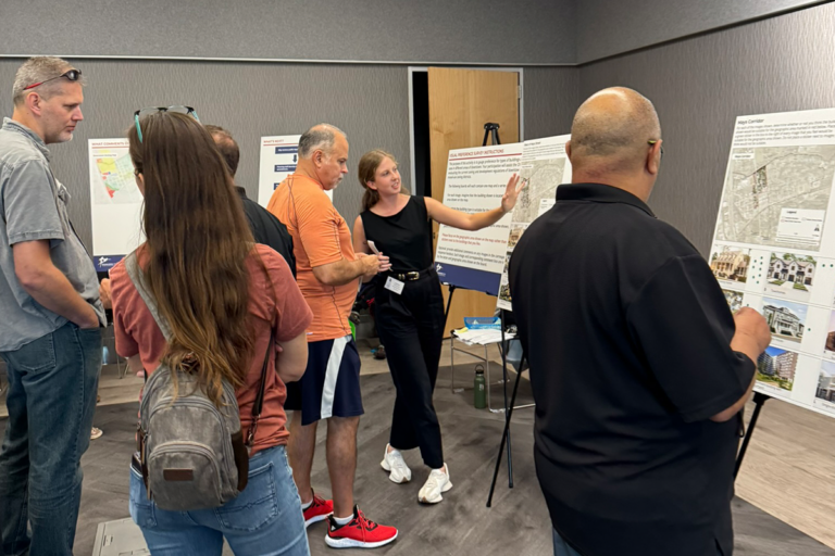 six people looking at display boards about zoning districts; two people are discussing the boards